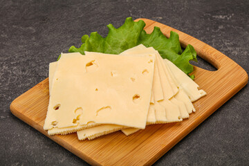 Sliced yellow cheese over board