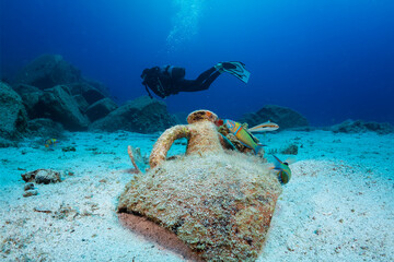 Scuba diving in Greece: an ancient, Greek Amphora with a diver silhouette behind