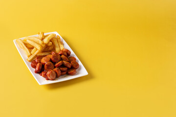 Traditional German currywurst on yellow background. Copy space