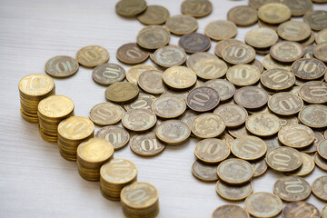 Russian coins with a nominal value of 10 rubles. Coins with a face value of 10 rubles are stacked in descending order. The background is made of money. Money background. Russian money.