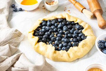 The process of making a French galette or pie with blueberries. Ingredients for summer baking on culinary background