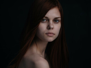 red-haired woman naked shoulders dark background glamor