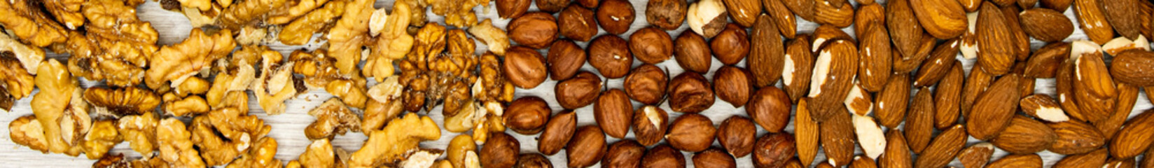 banner assortment of nuts hazelnuts, walnuts, almonds on wood table