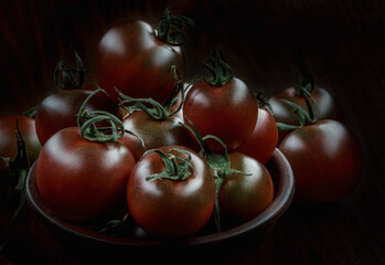 A lot of ripe juicy tomatoes on a black background. Black tomatoes.