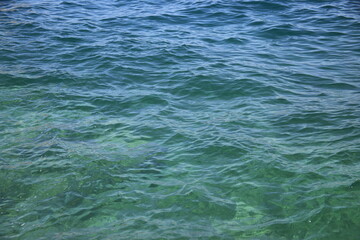 Obraz premium Abstract blue water background. Beautiful sparkling clear sea water. Clear sea water surface. High quality photo