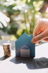 stacking dollars coins with a house model.save and investment for buy house concept . pastel tone.