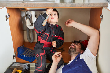 Son helps father install a sink