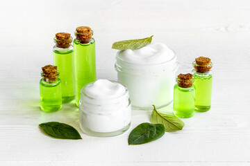 Tea tree cosmetics with essential oil and green leaves