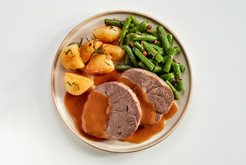 Tender succulent roast beef with green beans and potatoes