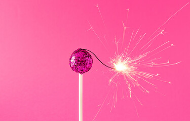 Creative idea of canday with pink glitter and party sparkles.Minimal happy christmas concept.