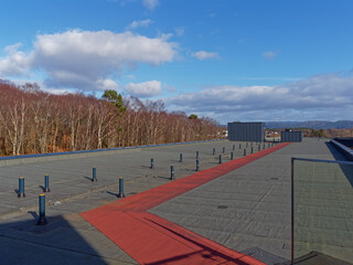 The Flat Roof with a Red Access Path of the Scandic Flesland airport Hotel in Bergen on a cold bright day in April.
