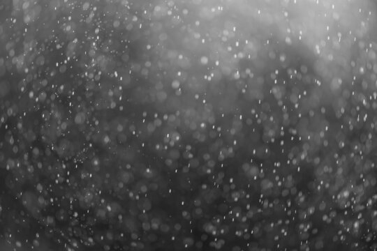 snow or rain bokeh texture overlay on black background.
