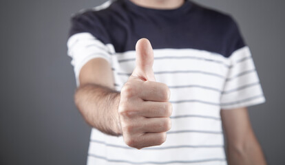 Caucasian man making a thumbs up gesture.