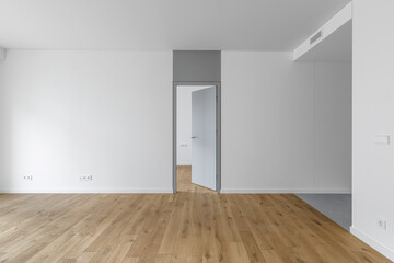 Empty minimalist modern room with white walls, opened grey door, grey floor tiles and oak wood floor