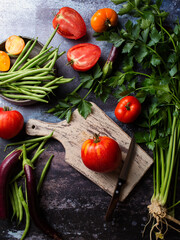 Vegetable still life. Harvest of tomatoes. Eggplant, celery, string beans. The chef prepares a vegetable lunch. Cutting a tomato. Cooking vegan food.