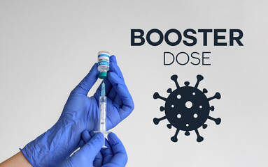 Medical worker holding covid syringe and vaccine in front of white background with booster dose text