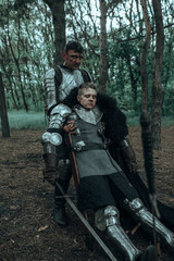 Fototapeta na wymiar Medieval knight in armour drags on the ground warrior wounded in battle.