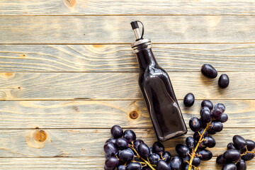 Bottle of balsamic vinegar with bunch of fresh grapes