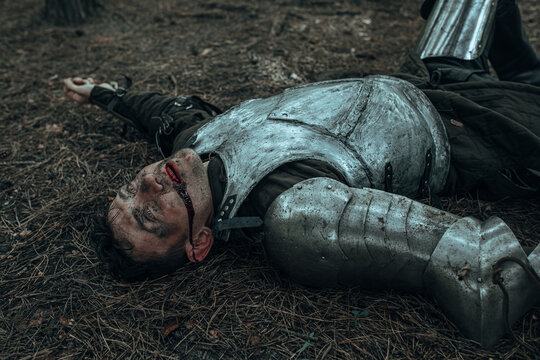 Defeated in battle medieval knight lies on battlefield.