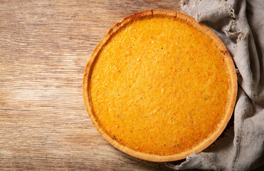 Pumpkin pie on a wooden background, top view