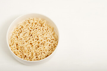 Instant noodles are placed in a white cup.
