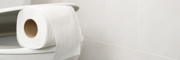 The toilet paper is on the toilet flush at home.