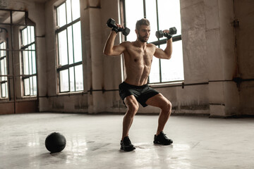 Muscular man doing weight exercise with dumbbells