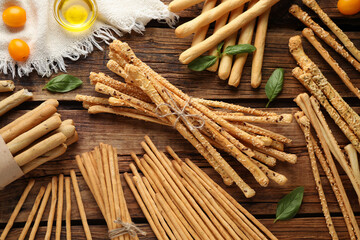 Flat lay composition with delicious grissini sticks on wooden table