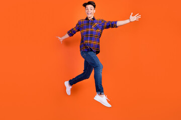 Fototapeta na wymiar Full size profile photo of millennial funny guy run wear shirt jeans sneakers isolated on orange background