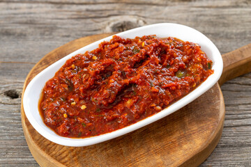 A spicy Turkish appetizer ezme made with tomatoes, bell pepper, parsley, mint, olive oil and hot chili. A kind of adjika