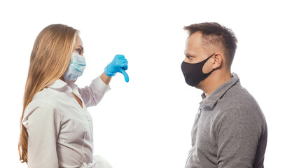 Medic showing thumb down to patient after body temperature test wearing a medical face mask. Sad man looking at her with sad eyes. Isolated on white background. 