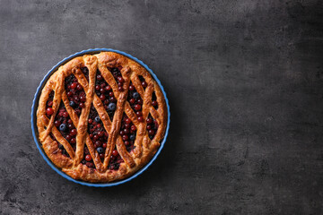 Delicious currant pie and fresh berries on grey table, top view. Space for text