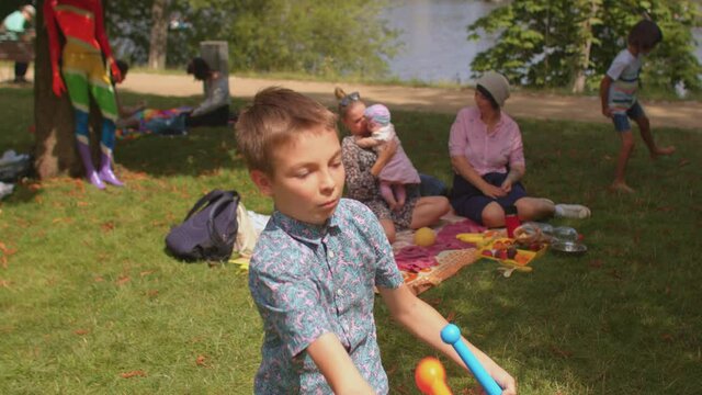 The boy tries to juggle with plastic colored juggling clubs are one of the three most popular props used by jugglers. Useful non-electronic toys for children.