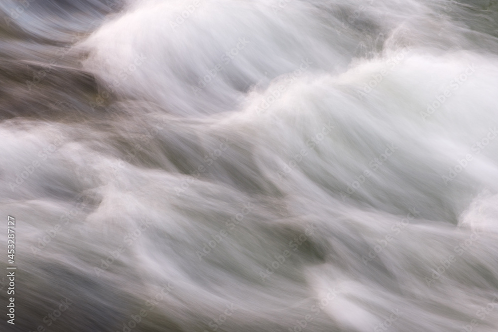 Poster abstract background from long exposure of water stream in a mountain river close-up