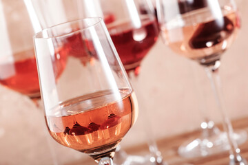 Rose wine glasses on the beige table. Rosado, rosato or blush wine tasting concept, negative space