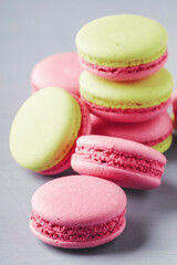 Fototapeta na wymiar Pink green macaroons cakes on gray blue table background, place for text, trendy minimalism style, selective focus