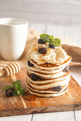 Pile of freshly cooked pancakes with blueberries on white background, morning breakfast meal