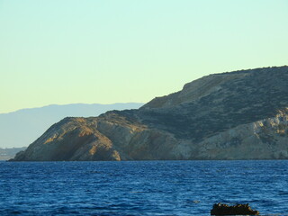 island in the sea. the rocky shores of Koufonisia as seen from the boat leading from one island to...