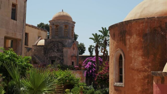 medieval mediterranean greek buildings with picturesque colorful plants and flowers in Greek Orthodox monastery Agia Triada Holy Trinity, Crete Greece