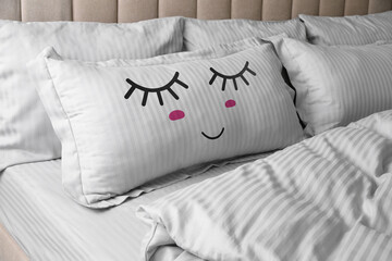 Soft pillow with cute face on comfortable bed