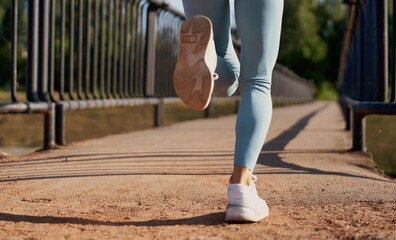 Beautiful female jogger running in the morning across bridge