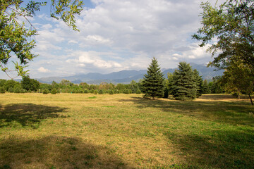Obraz premium Landscape of mountains and fields with trees and beautiful clouds