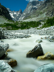 Blue water of mountain river flowing from the peaks, long exposure, National park Ecrins 
