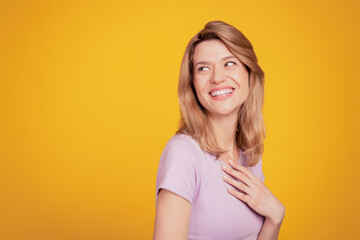 Obraz premium Portrait of grateful thankful lady hand chest look blank space on yellow background