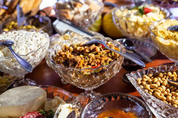 Detalhe de mesa de bufê de festa com diversas opções gastronômicas.