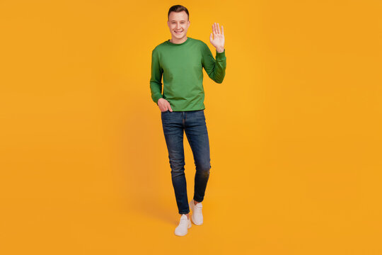 Portrait Of Friendly Neighbor Guy Walk Look Camera Wave Hand On Yellow Background