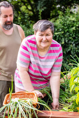 mentally handicapped woman and a caregiver standing at a raised bed in the garden