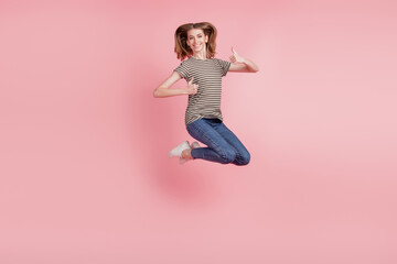 Fototapeta na wymiar Full body portrait of young woman happy positive smile show thumb-up like fine choice advert jump up isolated over pink color background
