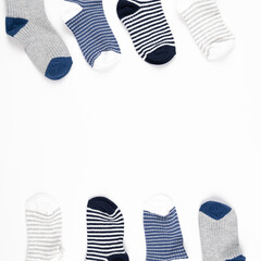 Frame made of various baby socks isolated on white