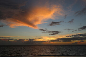 Beautiful yellow sunset over the ocean and different color sky